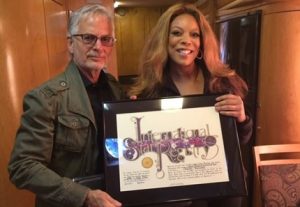 Image of Wendy Williams holding her framed star gift for when she had a star named after her